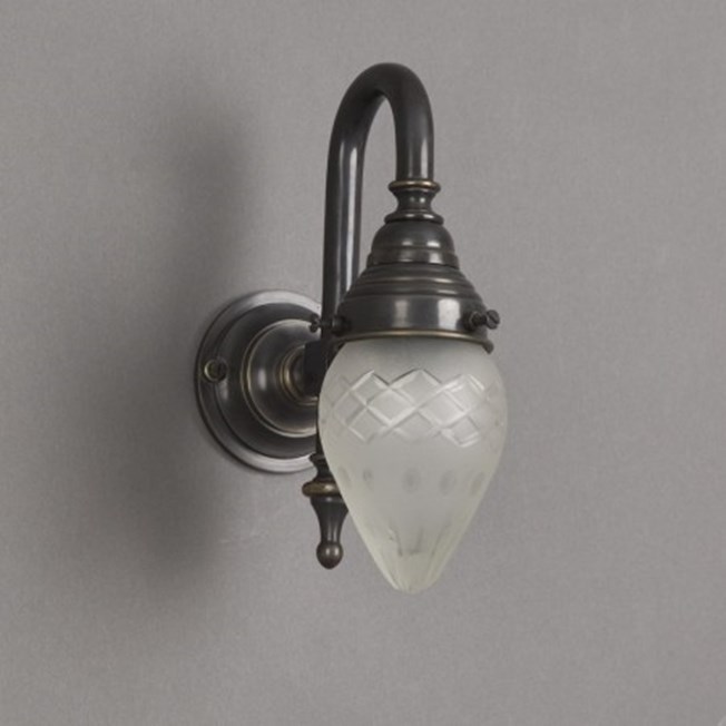 Badkamer wandlamp met bronzen armatuur en kleine, ellips vormige, rondom geslepen glaskap